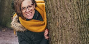 A woman hiding behind a tree