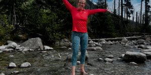 A woman standing in the river feeling happy