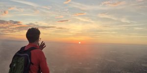 A Woman standing on top of a mountain during sunrise